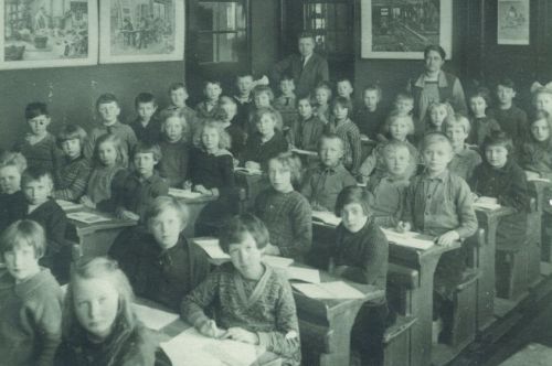 Vol klaslokaal in een lagere school in de jaren '20